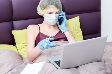 Covid-19 Coronavirus 'la evde çalış. Koruyucu eldivenli bir kız, maske ve saçında bir şapka. Yeni gerçeklik.