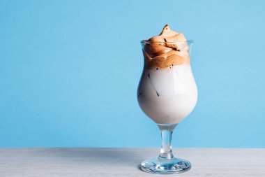 Mavi arka planda çırpılmış dalgona kahvesi..