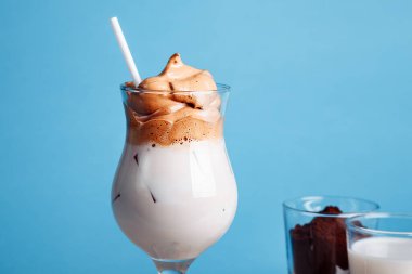 Mavi arka planda çırpılmış dalgona kahvesi..