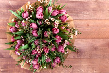 Laleli bir buket çiçek ve ahşap bir masada chamelaucium. yüksek kalite. üstten görünüm, metin için yer