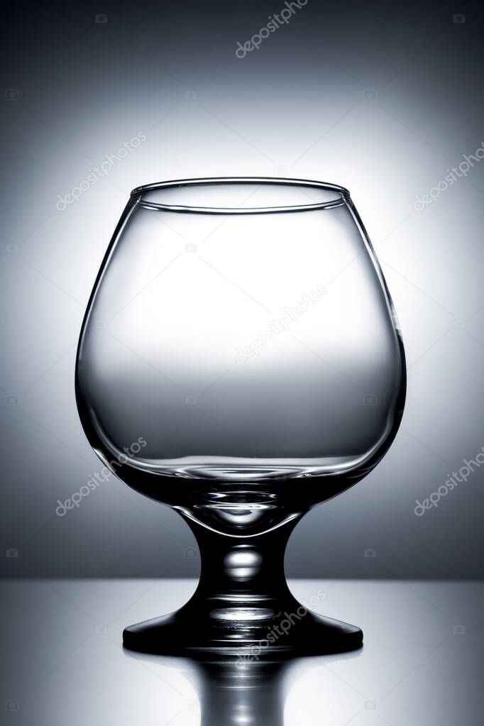 vertical photo empty clean transparent with glares glass for cognac on gray white background with gradient