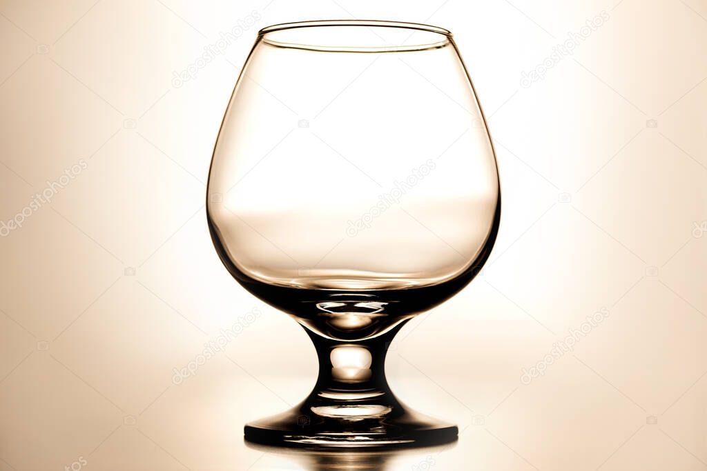 vertical photo empty clean transparent with glares glass for cognac on light beige background with gradient