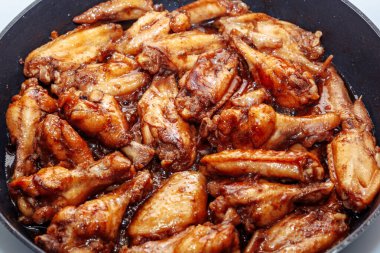 Tavada bir sürü kızarmış tavuk kanadı. Kapat.