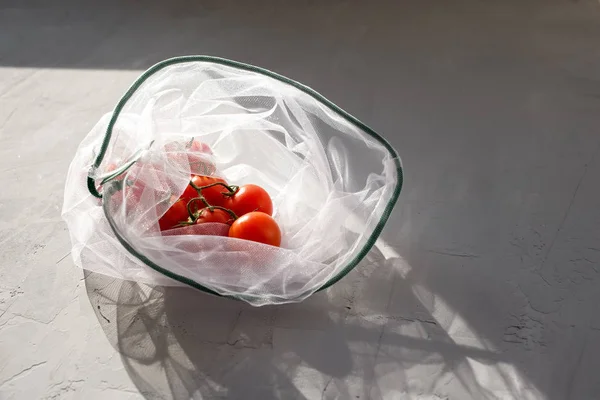 Beton bir arka planda, çevre dostu çantada domatesler.. — Stok fotoğraf