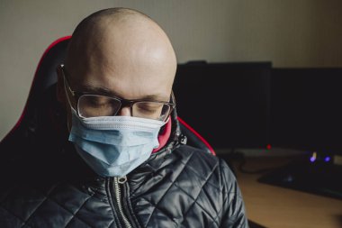 Tıbbi maske takan beyaz bir adamın başı ağrıyormuş ve uyuyakalmış. Çin 'den gelen hastalık korumalı koronavirüs salgını sorunu. Maskeler virüslerin yayılmasını engeller. Tıbbi konsept