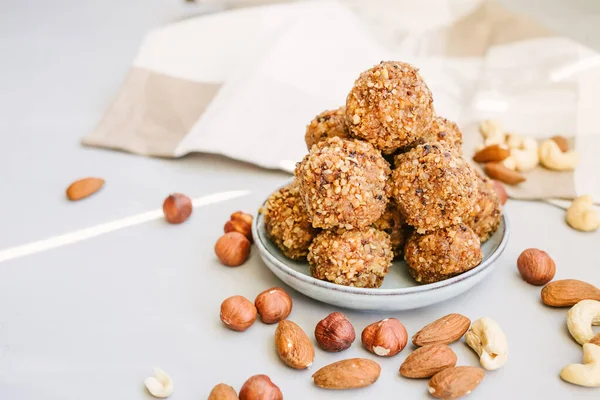 Handmade vegetarian sweet balls from moroccan dates with crushed almonds, raw healthy diet. Proper nutrition snack on light background.