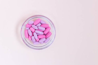 Bir kase pembe hap, tablet, vitamin, ilaç, ilaç ve sağlık hizmetleri için gıda takviyesi. Pembe arka plan. Sağlık konsepti. Düz yatıyordu. Boşluğu kopyala.