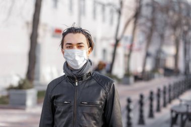 Karantina zamanında koruyucu maskeli beyaz bir gencin portresi. Koronavirüs kavramı. Avrupa 'daki gençlerin kişisel güvenliği. Sağlık ve bakım kavramı.