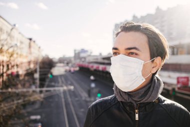 Karantina zamanında koruyucu maskeli beyaz bir gencin portresi. Koronavirüs kavramı. Avrupa 'daki gençlerin kişisel güvenliği. Sağlık ve bakım konsepti. Metin için boşluk
