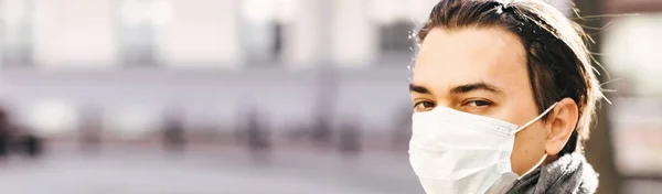 防護マスクの男が隔離された町を歩く 彼の顔には医療マスクの男のカメラを探している コロナウイルス ウイルス対策 病気の流行 バナー — ストック写真