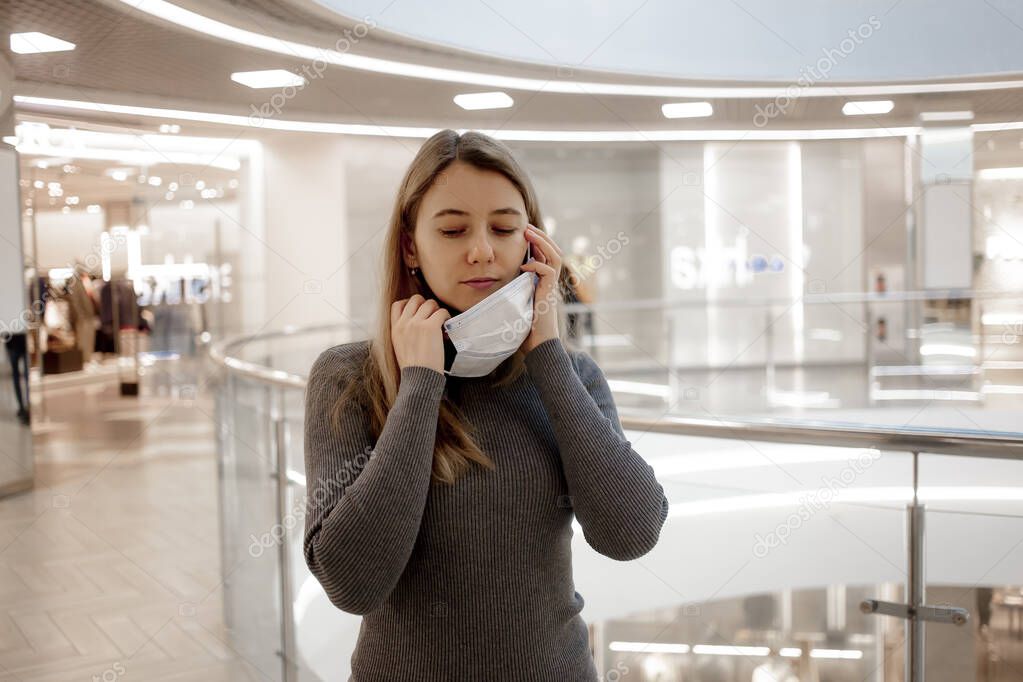 COVID-19 Pandemic Coronavirus Young girl in Mall removes protective mask from the face  for spreading of Coronavirus Disease 2019.  Danger. The end of epidemic. 