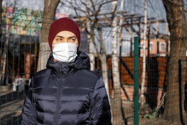 Karantina zamanında koruyucu maskeli beyaz bir gencin portresi. 2019 Coronavirus hastalığının yayılması için maske takan bir adam. Sağlık ve bakım kavramı.
