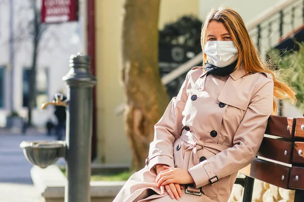 Woman in city street wearing face mask protective for spreading of disease virus SARS-CoV-2. COVID-19 Pandemic. Copy space.