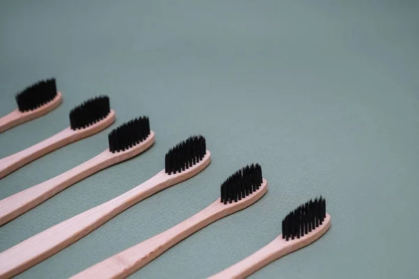 Brosses en bambou naturel sur fond vert. Produits d'hygiène buccodentaire respectueux de l'environnement . — Photo