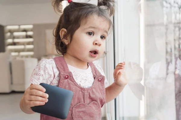 Dziecko Trzyma Kolumnę Ręku Dzieciak Wygląda Przez Okno Portret Dziewczyny — Zdjęcie stockowe