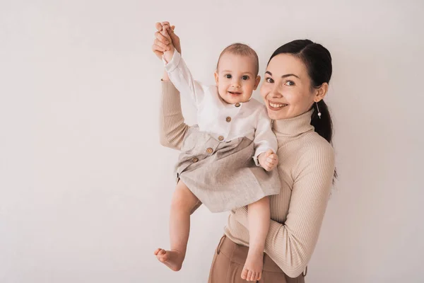 Happy mom portrait with daughter. International Mother\'s Day. A happy woman holds her baby in her arms