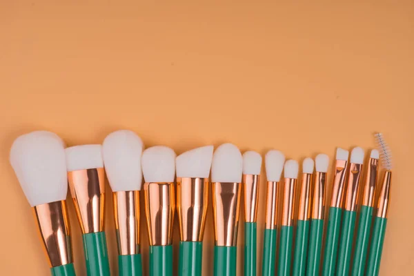 Maquillaje cepillos aislados pastel fondo — Foto de Stock