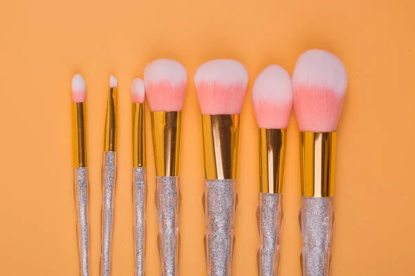 Maquillaje cepillos aislados pastel fondo — Foto de Stock