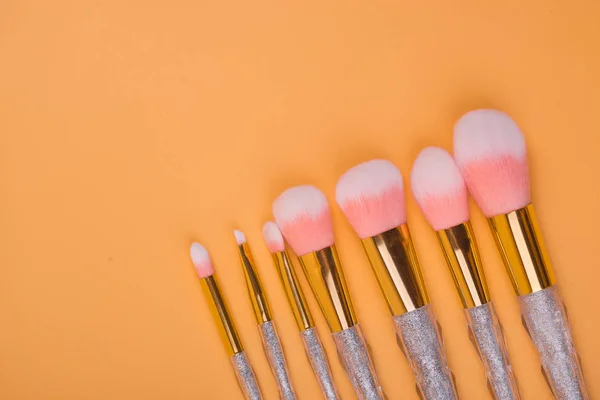 Maquillaje cepillos aislados pastel fondo — Foto de Stock