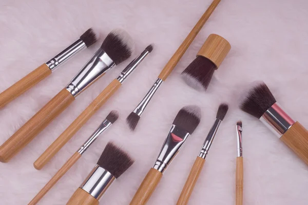 Makeup brush set on white fur background