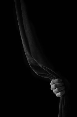 Bir adamın eli perdeyi tutar.