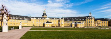 Karlsruhe Kalesi 'nin ana girişinde bahçe ve binalarla birlikte yan panorama. Karlsruhe, Baden-Wuerttemberg, Almanya
