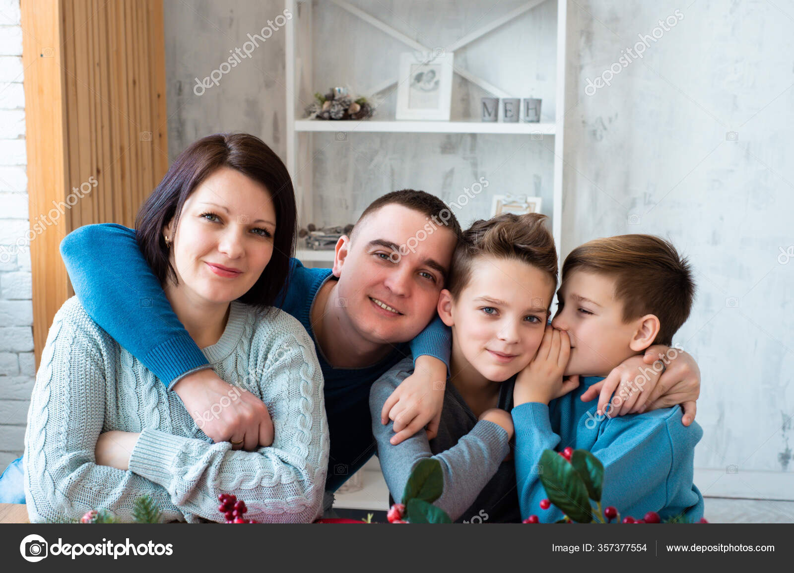 家中美丽幸福家庭的画像微笑的人们拥抱在一起爸爸和两个孩子坐在厨房里两个兄弟有秘密父母都很开心看着摄像机 家中美丽幸福家庭的画像微笑的人们拥抱在一起爸爸和两个孩子坐在厨房里两个兄弟有秘密父母都很开心看着摄像机