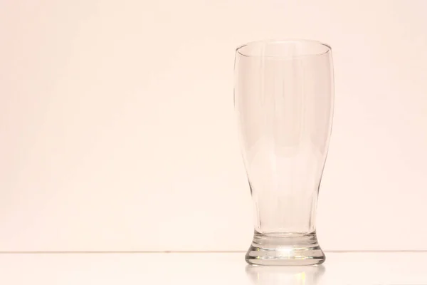 Üres átlátszó üveg sör világos háttér — Stock Fotó