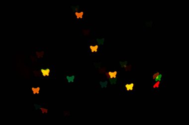 Siyah arka planda çok renkli kelebekler gibi güzel bir tarafı var.