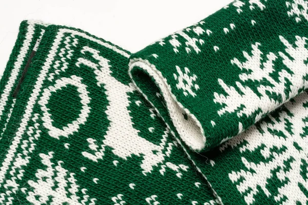 Фрагмент красивого зеленого шарфа з білими малюнками, що зображують оленя, ялину та сніжинки — стокове фото