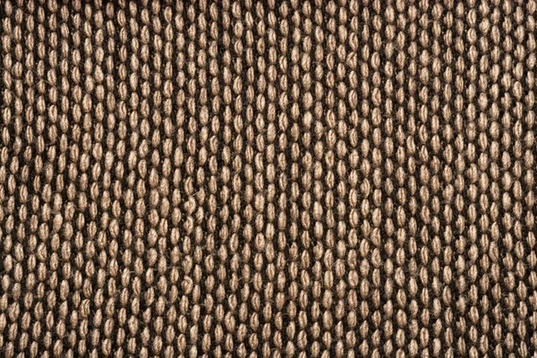 Fragment of knitted scarf of brown-black color with twisted edges. Vertical location on a white background. Close-up — Stock Photo, Image