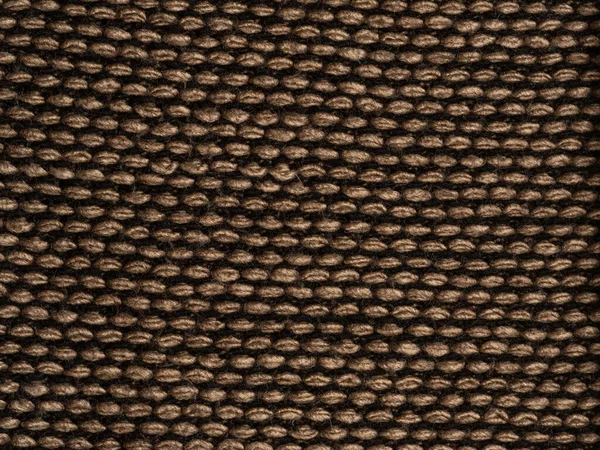 Fragment of knitted scarf of brown-black color with twisted edges. horizontal location on a white background. Close-up — Stock Photo, Image