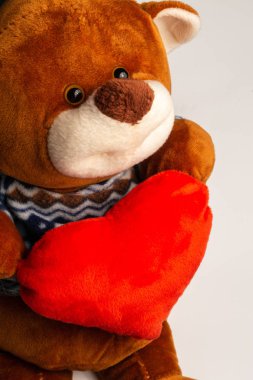 Teddy Bear 'ın beyaz arka planda kalbi var. Dikey oryantasyon. Kapat.