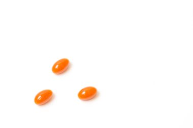 Three orange tablets lies on white background. View from above clipart