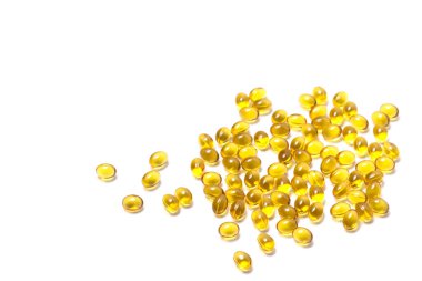 Beyaz zemin üzerinde çok sayıda saydam sarı renkli tablet. İzole edilmiş