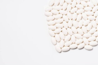 Beyaz arka planda çok sayıda beyaz oval şekilli tablet. Yukarıdan görüntüle