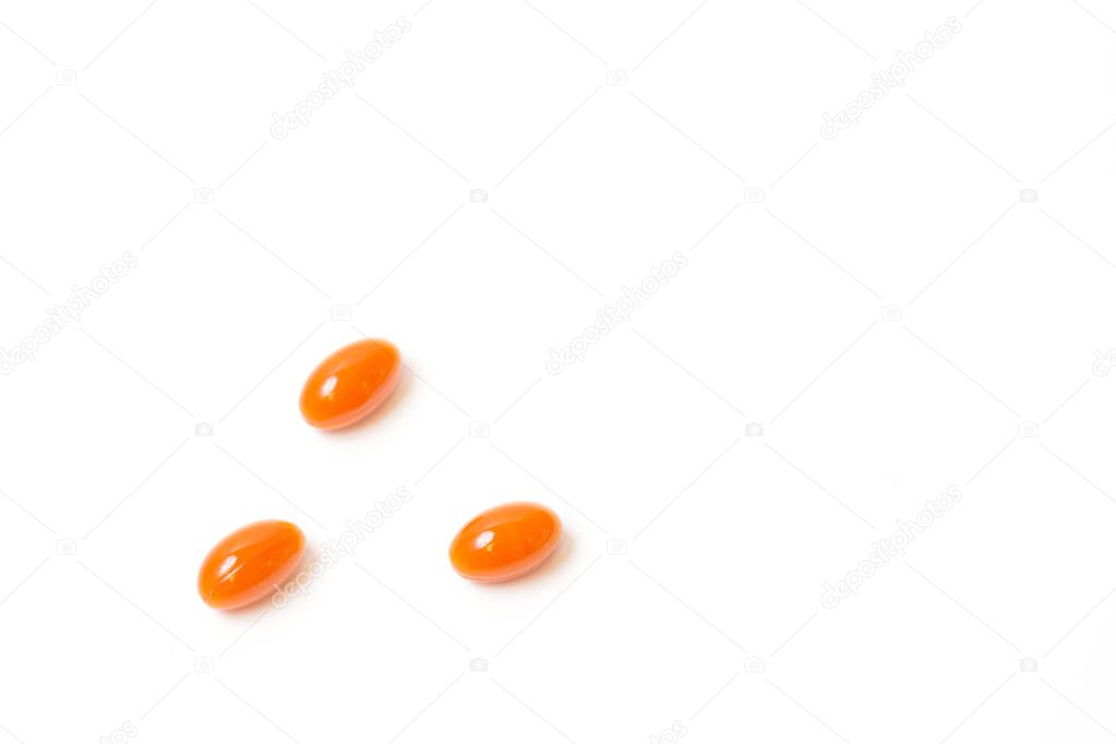 Three orange tablets lies on white background. View from above