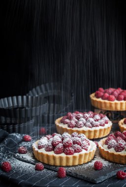 Koyu arka plan üzerinde lezzetli ahududu mini turta