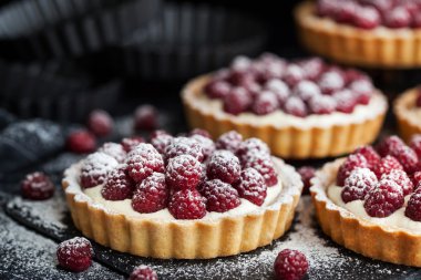 Koyu arka plan üzerinde lezzetli ahududu mini turta