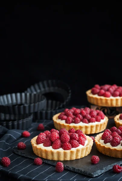 Delicious raspberry mini tarts on dark background — Stock Photo, Image