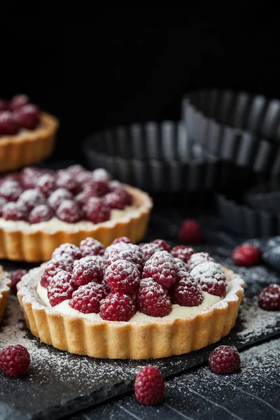 Tarte mini delicioase de zmeură pe fundal întunecat — Fotografie, imagine de stoc