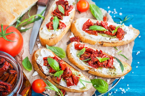 Bruschetta with cream cheese, pesto, fresh basil and sun dried t — Stock Photo, Image