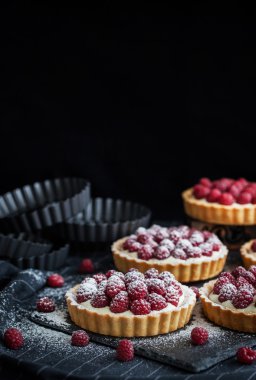 Koyu arka plan üzerinde lezzetli ahududu mini turta