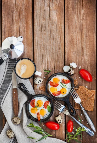 Fried eggs with tomatoes in frying pans — Stock Photo, Image