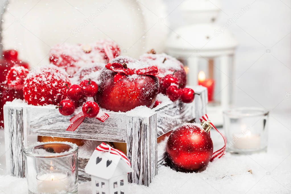 Christmas composition with red apples, balls, cinnamon, snow and