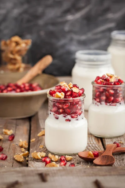 Yogur fresco con semillas de granada y nuez en frascos de vidrio — Foto de Stock