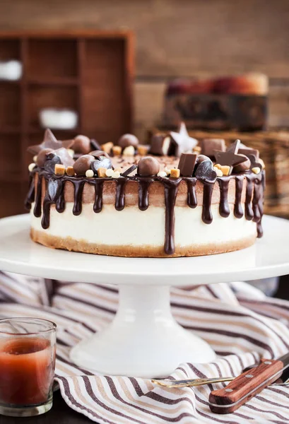 Två skikt chokladcheesecake dekorerad med godis och glasyr — Stockfoto