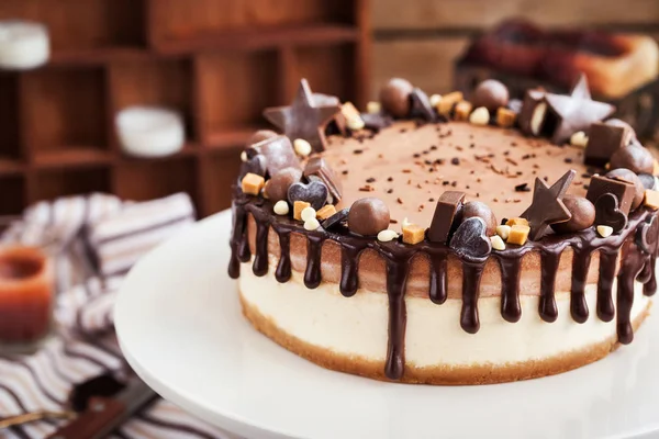 Två skikt chokladcheesecake dekorerad med godis och glasyr — Stockfoto