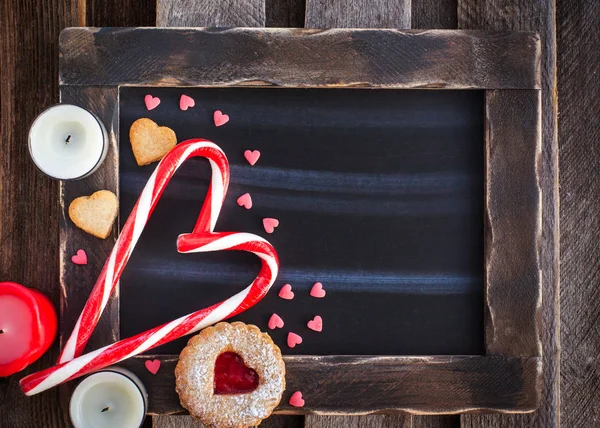 Chalk board e doces em forma de coração e biscoitos — Fotografia de Stock