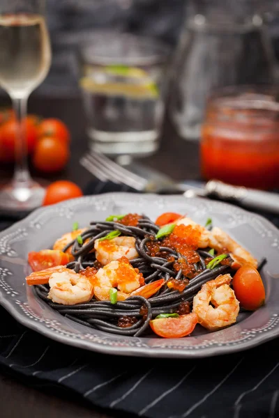 Zwarte spaghetti met garnalen en rode kaviaar — Stockfoto